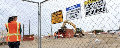 This Aug. 7, 2014, image shows a contract employee watching a crews excavate contaminated soil at a site where millions of gallons of jet fuel leaked underground over decades at Kirtland Air Force Base in Albuquerque, N.M. After excavating thousands of tons of soil and treating millions of gallons of water, New Mexico regulators say the U.S. Air Force still has work to do to clean up the contamination. (AP Photo/Susan Montoya Bryan)