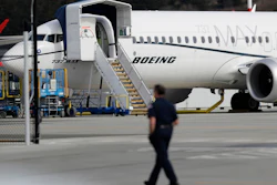 In this March 14, 2019, file photo, a worker walks next to a Boeing 737 MAX 8 airplane parked at Boeing Field in Seattle. Image credit: AP Photo/Ted S. Warren, File