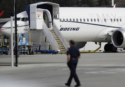 In this March 14, 2019, file photo, a worker walks next to a Boeing 737 MAX 8 airplane parked at Boeing Field in Seattle. Image credit: AP Photo/Ted S. Warren, File