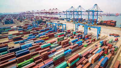 In this March 8, 2019, photo, trucks move at a container port in Qingdao in eastern China's Shandong Province. Image credit: Chinatopix via AP