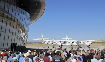 In this Oct. 17, 2011, file photo a crowd gathers outside Spaceport America for a dedication ceremony as Virgin Galactic's mothership WhiteKnightTwo sits on the tarmac near Upham, N.M. Image credit: AP Photo/Susan Montoya Bryan, File