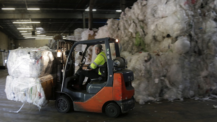 In this May 7, 2019 photo, a forklift moves through stacks of recyclables at a GDB International warehouse in Monmouth Junction, N.J. Image credit: AP Photo/Seth Wenig