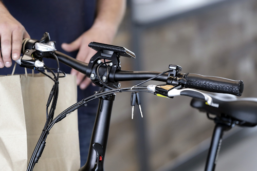 In this photo taken Wednesday, May 15, 2019, a Rad Power Bikes sales associate stands with an electric bicycle he's delivering to a customer at the shop in Seattle, where the bicycle company said that they will absorb 100% of any tariff on their Chinese-made bicycles. Image credit: AP Photo/Elaine Thompson