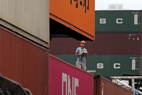 A staff member checks cargos at a port of Kwai Tsing Container Terminals in Hong Kong, Friday, May 24, 2019. Kwai Tsing Container Terminals is one of the busiest ports in the world. Image credit: AP Photo/Kin Cheung