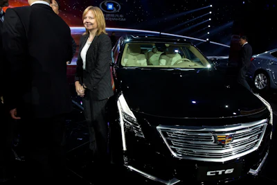 In this April 19, 2015, file photo General Motors CEO Mary Barra stands next to the Cadillac CT6 luxury sedan during a General Motors event ahead of the Auto Shanghai show in Shanghai, China. Image credit: AP Photo/Ng Han Guan, File