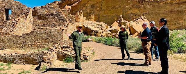 In this photo provided by the Navajo Nation, Interior Secretary David Bernhardt, center, tours Chaco Culture National Historical Park about 95 miles northeast of Gallup, New Mexico, on Tuesday, May 28, 2019. U.S. Sen. Martin Heinrich of New Mexico is at Bernhardt's right. Navajo Nation President Jonathan Nez is on his left. (Jared Touchin/Navajo Nation via AP)