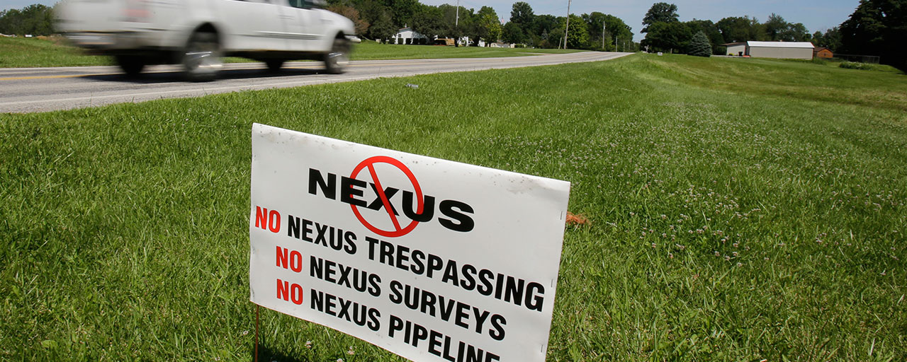 In this Thursday, July 16, 2015, file photo, a truck passes a sign against Nexus on the property of Kathy Cikotte, in Berlin Heights, Ohio. An Ohio city and others are asking federal appeals judges in Washington to rule that their property was illegally seized to build a $2 billion pipeline that sends large quantities of natural gas to Canada. (AP Photo/Tony Dejak)