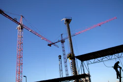 In this Oct. 23 file photo, a worker climbs a ladder as cranes work the construction site for the new corporate headquarters of Norfolk Southern Railway in Atlanta.