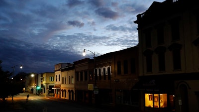 In this Oct. 28, 2017 file photo, the storefront window of a portrait studio is lit up along a downtown street at dusk in Lumberton, N.C. With a little over one month to go in 2019, small business owners should think about purchases or investments that make good business sense and will give them a break on their taxes.