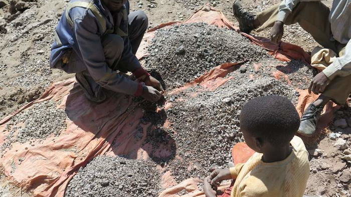 François and his 13-year-old son, Charles, sort stones before taking them to a nearby trading house that buys the ore, Democratic Republic of Congo, 2016.