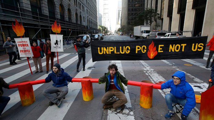 Protesters block traffic on Beale Street where a Pacific Gas & Electric building is located in San Francisco, Monday, Dec. 16, 2019. Pacific Gas & Electric will have to quickly reshuffle its board of directors and redraw a complex plan addressing more than $50 billion in potential wildfire claims to gain Gov. Gavin Newsom's support in time to meet a fast-approaching deadline to emerge from bankruptcy protection.