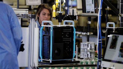 In this Nov. 20, 2019 file photo, workers with Apple products being assembled before President Donald Trump tours an Apple manufacturing plant in Austin, TX.