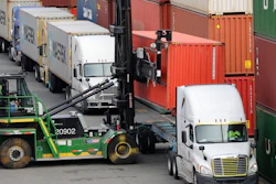 In this Oct. 2, 2019 file photo, a shipping container is lifted off the back of a truck as others wait in line to have their cargo unloaded at a terminal on Harbor Island in Seattle.