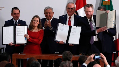 Mexico's Treasury Secretary Arturo Herrera, left, Deputy Prime Minister of Canada Chrystia Freeland, second left, Mexico's President Andres Manuel Lopez Obrador, center, Mexico's top trade negotiator Jesus Seade, second right, and U.S. Trade Representative Robert Lighthizer, hold the documents after signing an update to the North American Free Trade Agreement, at the national palace in Mexico City on Tuesday, Dec. 10.