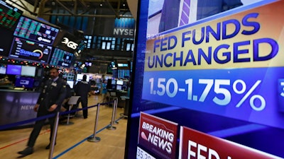 A television screen on the floor of the New York Stock Exchange shows the rate decision of the Federal Reserve on Wednesday, Dec. 11.