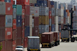 In this July 22, 2019 file photo, stacked containers wait to be loaded on to trucks at the Port of Oakland in Oakland, CA. China's government says trade negotiators are in “close communication” with Washington ahead of a weekend deadline for a U.S. tariff hike.