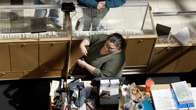 In this April 9, 2018 file photo a cashier rings up a purchase at a store in Salem, NH.