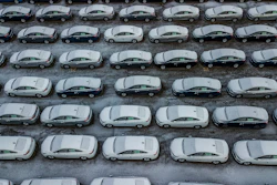In this Dec. 5, 2018 file photo, hundreds of Chevrolet Cruze cars sit in a parking lot at General Motors' assembly plant in Lordstown, OH. The long-struggling Rust Belt community of Youngstown, Ohio, which was stung by the loss of the massive General Motors Lordstown plant this year, wants to become a research and production hub for electric vehicles.. But Youngstown faces competition from places like Detroit and China that are taking big roles in developing electric vehicles.