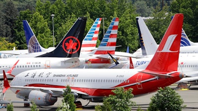 In this Thursday, June 27, 2019 file photo, dozens of grounded Boeing 737 MAX airplanes crowd a parking area adjacent to Boeing Field in Seattle. Safety regulators want to fine Boeing nearly $4 million, saying that the company installed critical wing parts on 133 planes even though it knew the parts were faulty. The Federal Aviation Administration announced the proposed civil penalty on Friday, Dec. 6, 2019.