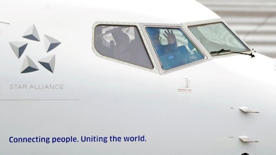 A pilot waves from the flight deck of a United Airlines Boeing 737 Max airplane prior to a flight Wednesday, Dec. 11, 2019, at Renton Municipal Airport in Renton, Wash. After the first crash of a Boeing 737 Max in 2018, federal safety officials estimated that there could be 15 more fatal crashes of the Max over the next few decades if Boeing didn't fix a critical automated flight-control system, the chairman of the House Transportation Committee said Wednesday during opening remarks at the committee's fifth hearing on the Boeing 737 Max.