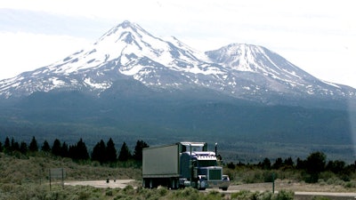 In this June 19, 2008 file photo, a truck drives past Mt. Shasta, near Weed, Calif. California regulators will hold a public hearing on Thursday, Dec. 12, 2019 about whether to require a certain percentage of truck sales to be zero emission vehicles. California has some of the worst air quality in the nation, largely driven by pollution from cars and trucks.