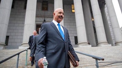 In this Oct. 22, 2019, file photo, Ted Wells, Jr., the lead attorney for Exxon, leaves New York Supreme Court in New York, after opening arguments in a lawsuit against Exxon. Exxon Mobil prevailed Tuesday, Dec. 10, 2019, in a lawsuit accusing the energy giant of downplaying the toll that climate change regulations could take on its business, with a judge saying the state attorney general's case didn't prove the company deceived investors — but also didn't excuse it of any accountability for global warming.