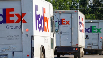 In this June 26, 2019, file photo delivery vehicles depart the FedEx Ship Center in Cranberry Township, Pa. FedEx reports earnings Tuesday, Dec. 17.