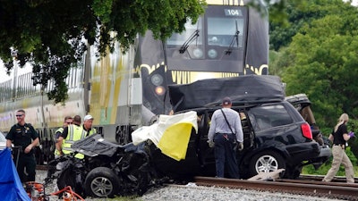 In this Aug 25, 2019 file photo, Broward Sheriff's Deputies and Pompano Beach Fire Rescue work the scene of a fatal accident on North Dixie Highway in Pompano Beach, Fla. The Florida higher-speed passenger train service tied to Richard Branson’s Virgin Group has the worst per-mile death rate in the U.S. The first death involving a Brightline train happened in July 2017 during test runs. An Associated Press analysis of Federal Railroad Administration data shows that since then, 40 more have been killed. That amounts to a rate of more than one a month and about one for every 29,000 miles (47,000 kilometers) the trains have traveled since the first death.