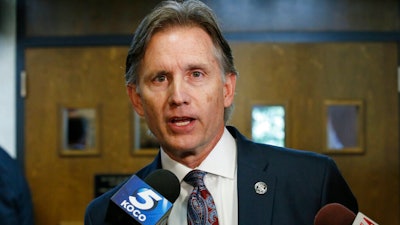 In this Oct. 15, 2019 file photo, Oklahoma Attorney General Mike Hunter talks with reporters following a hearing to settle disagreements between Johnson & Johnson and the State over Judge Thad Balkman's final judgement in the opioid lawsuit, in Norman, Okla. The state of Oklahoma filed an appeal Monday, Dec. 16, 2019 to a judge's order that Johnson & Johnson pay $465 million to address the state's opioid crisis. Hunter's office argues the award is only enough to pay for one year of the state's abatement plan.