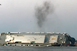 In a Sunday, Sept. 8, 2019 file photo, smoke rises from a cargo ship that capsized in the St. Simons Island, Georgia sound. Crews have finished draining all of the fuel from an overturned cargo ship three months after it capsized off the coast of Georgia, the team overseeing salvage operations said Thursday, Dec. 12, 2019.