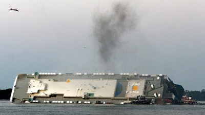 In a Sunday, Sept. 8, 2019 file photo, smoke rises from a cargo ship that capsized in the St. Simons Island, Georgia sound. Crews have finished draining all of the fuel from an overturned cargo ship three months after it capsized off the coast of Georgia, the team overseeing salvage operations said Thursday, Dec. 12, 2019.