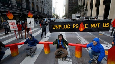 Protesters block traffic on Beale Street where a Pacific Gas & Electric building is located in San Francisco, Monday, Dec. 16, 2019. Pacific Gas & Electric will have to quickly reshuffle its board of directors and redraw a complex plan addressing more than $50 billion in potential wildfire claims to gain Gov. Gavin Newsom's support in time to meet a fast-approaching deadline to emerge from bankruptcy protection.