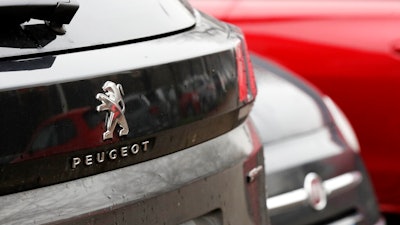 A Peugeot 3008 car is parked flanked by a 500 Fiat car in Milan, Italy, Wednesday, Dec. 18, 2019. Fiat Chrysler and PSA Peugeot have signed a deal for a 50-50 merger, creating the world's fourth-largest automaker with annual sales of 8.7 million cars.