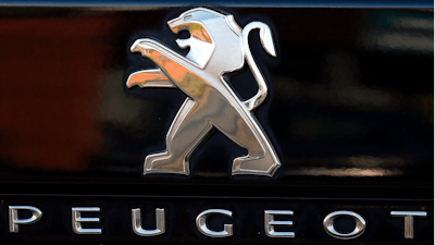 In this Oct. 31, 2019, file photo, a Peugeot logo pictured on a car in Bayonne, southwestern France. Fiat Chrysler Automobiles and PSA Peugeot announced Wednesday, Dec. 18, 2019, that their boards signed a binding deal to merge the two automakers, creating the world’s fourth-largest auto company.