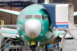 A worker looks up underneath a Boeing 737 MAX jet Monday, Dec. 16, 2019, in Renton, Wash. Shares of Boeing fell before the opening bell on a report that the company may cut production of its troubled 737 MAX or even end production all together.