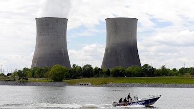 In this April 29, 2015 file photo, a boat travels on the Tennessee River near the Watts Bar Nuclear Plant near Spring City, Tenn. Federal regulators have fined the nation’s largest public utility $145,000 for submitting incomplete and inaccurate information on a backup system at its Watts Bar Nuclear Plant. The Nuclear Regulatory Commission notified the Tennessee Valley Authority of the proposed fine regarding the Spring City, Tennessee plant in a Nov. 19, 2019 letter. The utility says it has taken corrective action, adding that the backup configuration was never used.