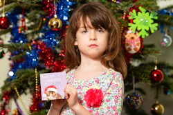 Florence Widdicombe, 6, poses with a Tesco Christmas card from the same pack as a card she found containing a message from a Chinese prisoner, in London, Sunday, Dec. 22, 2019. The U.K.-based grocery chain Tesco has halted production at a factory in China after a British newspaper said it used forced labor to produce charity Christmas cards. Tesco said Sunday it had stopped production and launched an investigation after the Sunday Times newspaper raised questions about the factory's labor practices.