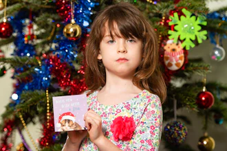 Florence Widdicombe, 6, poses with a Tesco Christmas card from the same pack as a card she found containing a message from a Chinese prisoner, in London, Sunday, Dec. 22, 2019. The U.K.-based grocery chain Tesco has halted production at a factory in China after a British newspaper said it used forced labor to produce charity Christmas cards. Tesco said Sunday it had stopped production and launched an investigation after the Sunday Times newspaper raised questions about the factory's labor practices.