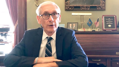 Wisconsin Gov. Tony Evers sits for an interview with The Associated Press Thursday, Dec. 19, 2019, saying that Foxconn Technology Group, the world's largest electronics manufacturer, could still qualify for up to $3 billion in state tax credits in Wisconsin if it makes changes to its deal with the state to reflect current plans for a plant that's under construction. Evers said Thursday. 'If we have a deal that is reflective of what they are doing, it's logical that they will get the credits,' 'But if they don't, that's a whole different deal.'