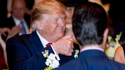 President Donald Trump gives a thumbs-up after arriving for Christmas Eve dinner at Mar-a-lago in Palm Beach, FL on Dec. 24.