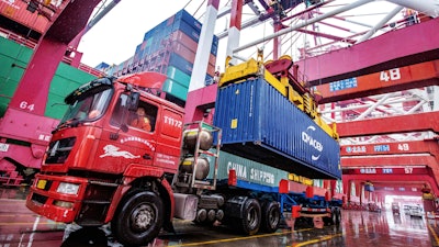 A worker waits to transport containers at the container port in Qingdao in eastern China's Shandong province on Tuesday, Jan. 14.