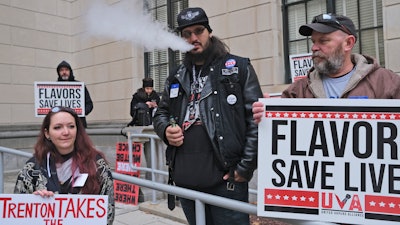 In this Jan. 13 file photo, Matthew Elliot, center, and other supporters of flavored vaping products protest at the state house in Trenton, NJ.