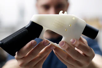 In this Aug. 1, 2018 file photo, Cody Wilson, with Defense Distributed, holds a 3D-printed gun called the Liberator at his shop in Austin, TX.