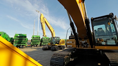In this Nov. 4, 2019, file photo construction equipment made by Caterpillar are readied for export to Asia at the Port of Tacoma in Tacoma, WA