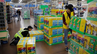 In this Nov. 27, 2019 file photo, Jayln Martin, right, and Dan Villegas stock items in preparation for a holiday sale at a Walmart Supercenter in Las Vegas.