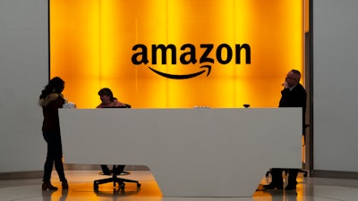 In this Feb. 14, 2019 file photo, people stand in the lobby for Amazon offices in New York.