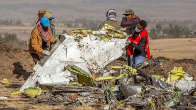In this file photo dated Monday, March 11, 2019, rescuers work at the scene of an Ethiopian Airlines plane crash south of Addis Ababa, Ethiopia.