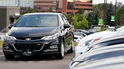 In this June 26, 2018, file photograph, a used 2017 Chevrolet Cruze sits in a row of other used, late-model sedans at a dealership in Centennial, Colo. Consumers bought an estimated 40.4 million used vehicles last year, likely passing the old record of 40.2 million set in 2018, according to figures from the Edmunds.com auto pricing site.