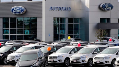 In this Thursday, Aug. 15, 2019 file photo,Cars for sale at the Ford dealership in Manchester, N.H. New vehicle sales in the U.S. fell slightly last year, but the numbers still passed the healthy 17 million mark for the fifth straight year. Automakers sold 17.1 million new cars, trucks and SUVs in 2019, down about 1% from the previous year.