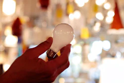 In this Jan. 21, 2011 file photo, manager Nick Reynoza holds a 100-watt incandescent light bulb at Royal Lighting in Los Angeles. A federal judge on Tuesday, Dec. 31, 2019, allowed California's updated light bulb efficiency standards to take effect with the new year Wednesday, Jan. 1, 2020. U.S. District Judge Kimberly Mueller of Sacramento rejected a petition from the National Electrical Manufacturers Association and the American Lighting Association to temporarily block new minimum efficiency standards for light bulbs that were adopted by the California Energy Commission in November.